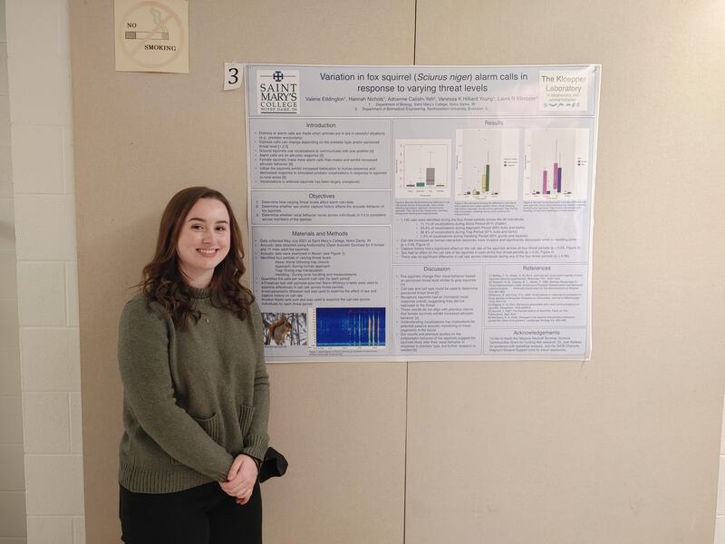 Valerie Eddington standing in front of her research poster (title: Variation in fox squirrel (Sciurus niger) alarm calls in response to varying threat levels). 